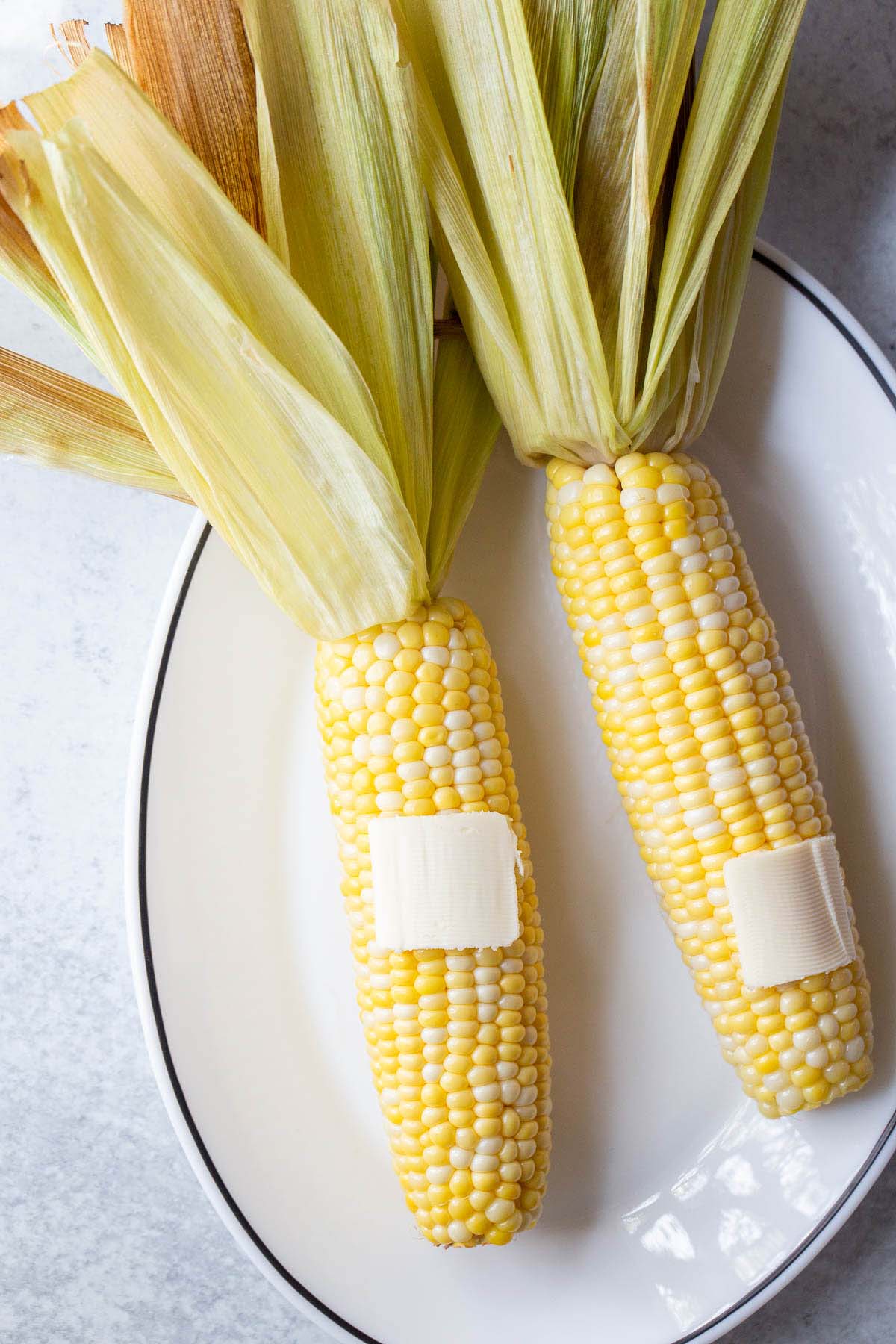 Corn on the cob with butter on top.