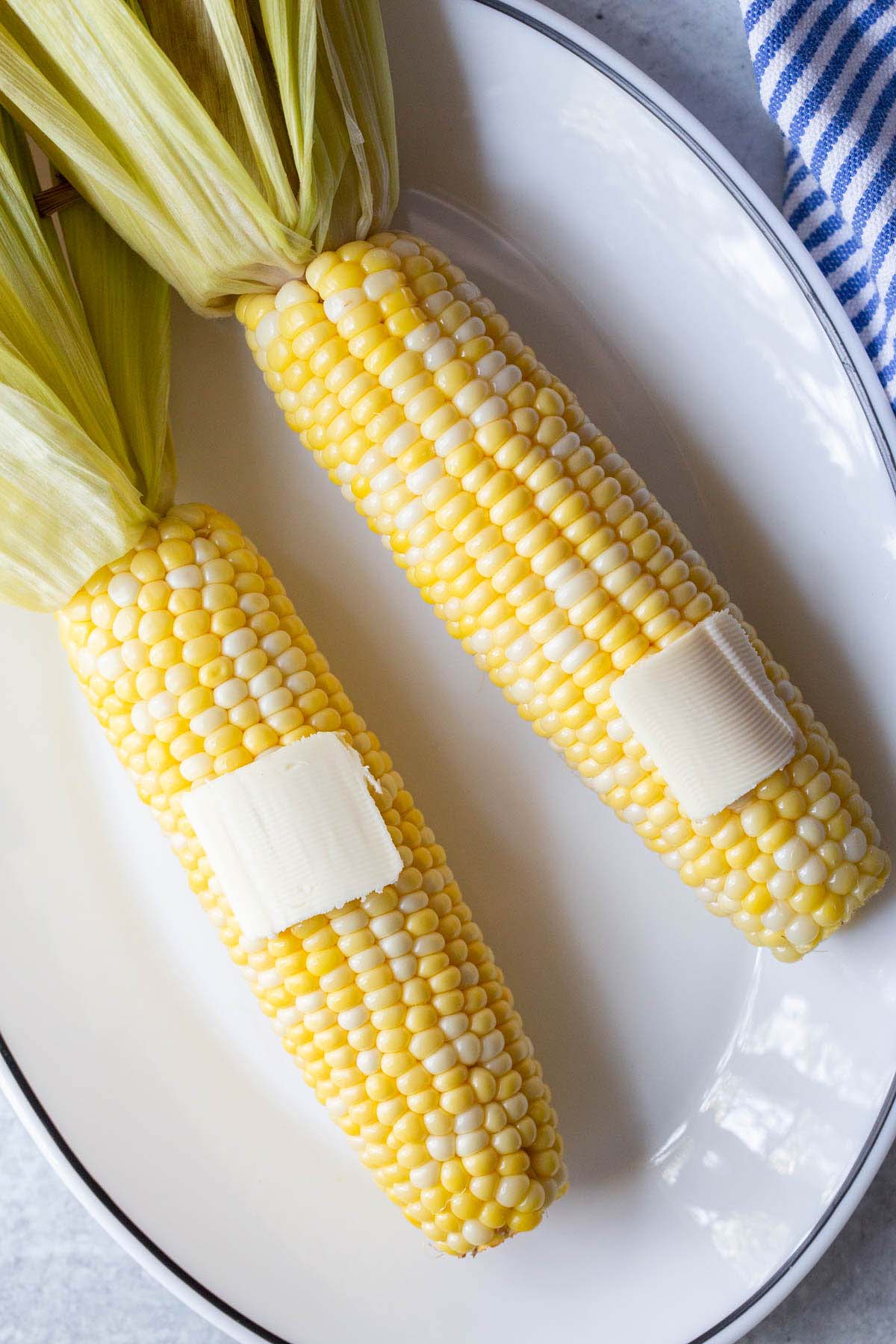 Corn on the cob with butter on top.