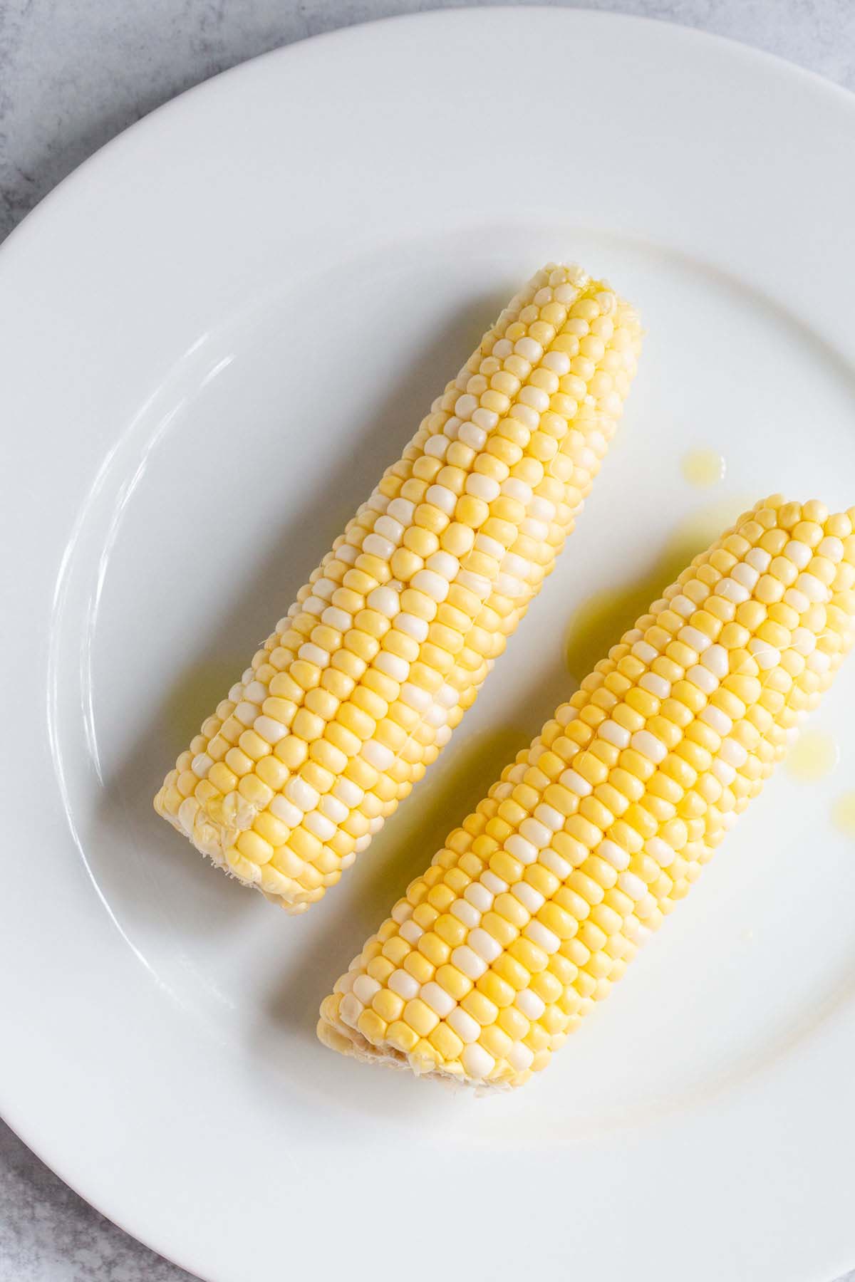 Uncooked corn on a white plate