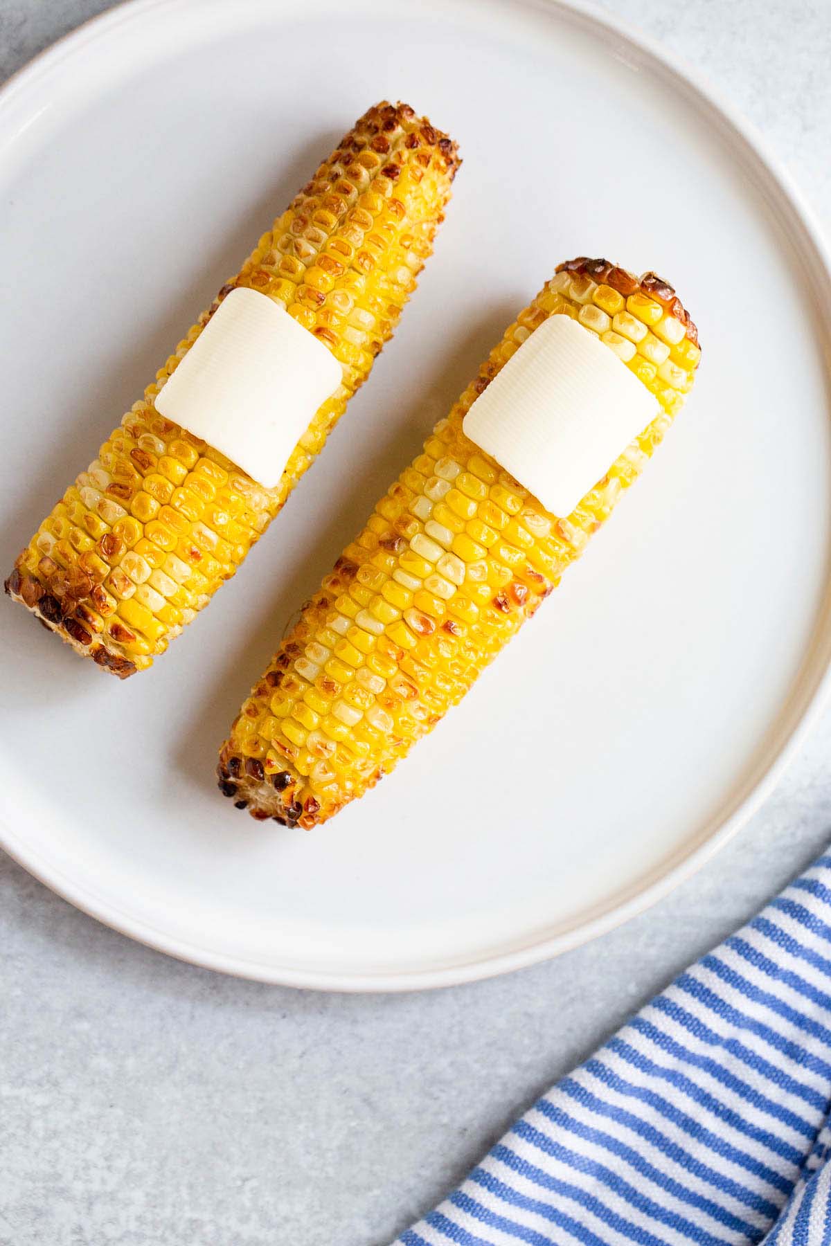 Air fried corn on the cob topped with pats of butter