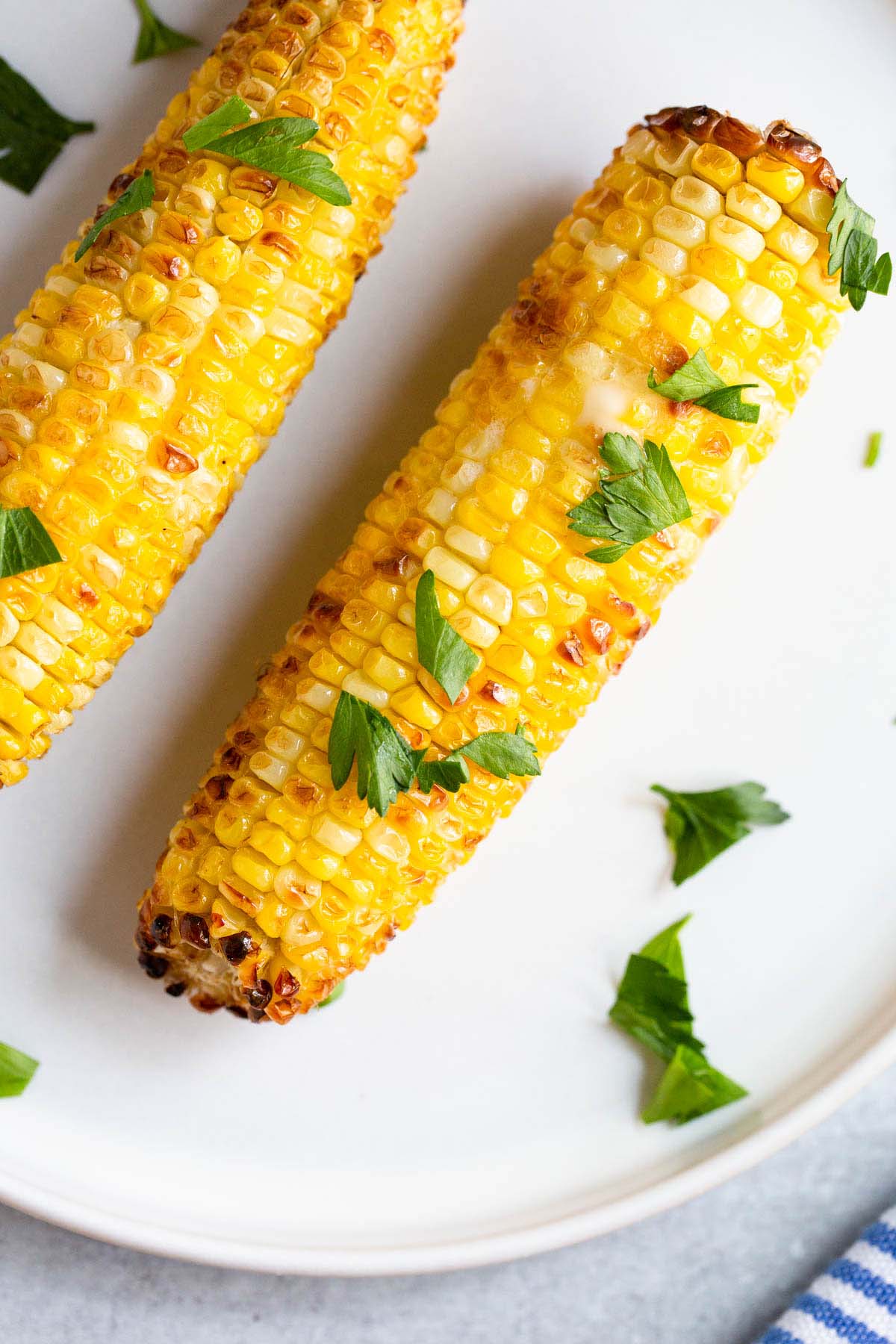 Air fried corn on the cob topped with fresh parsley