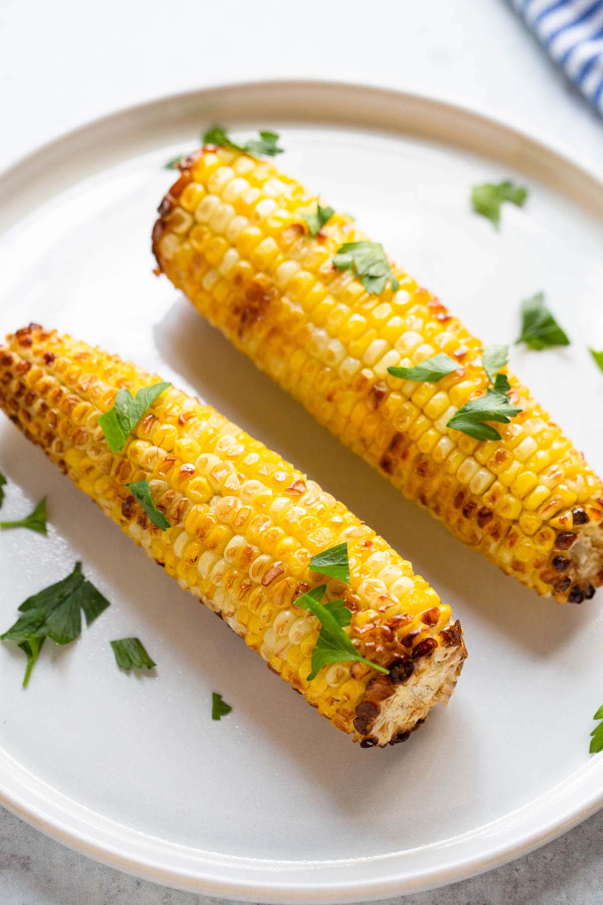 Air fried corn on the cob topped with fresh parsley