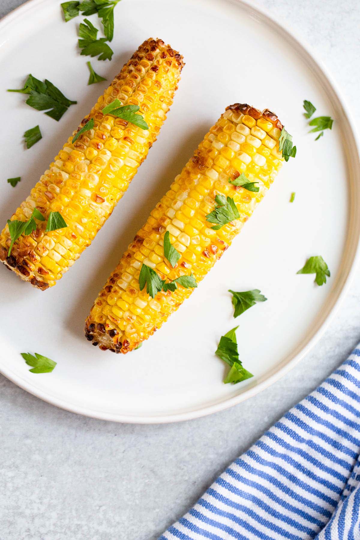 Air fried corn on the cob topped with fresh parsley