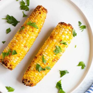 Air fried corn on the cob topped with fresh parsley