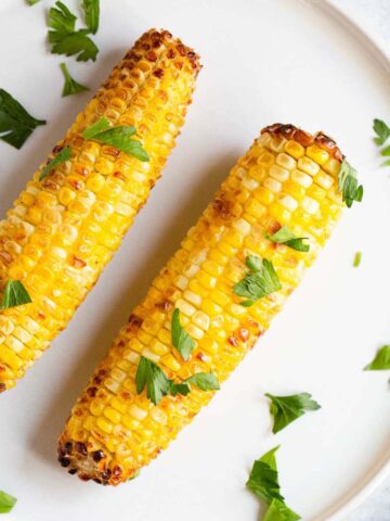 Air fried corn on the cob topped with fresh parsley