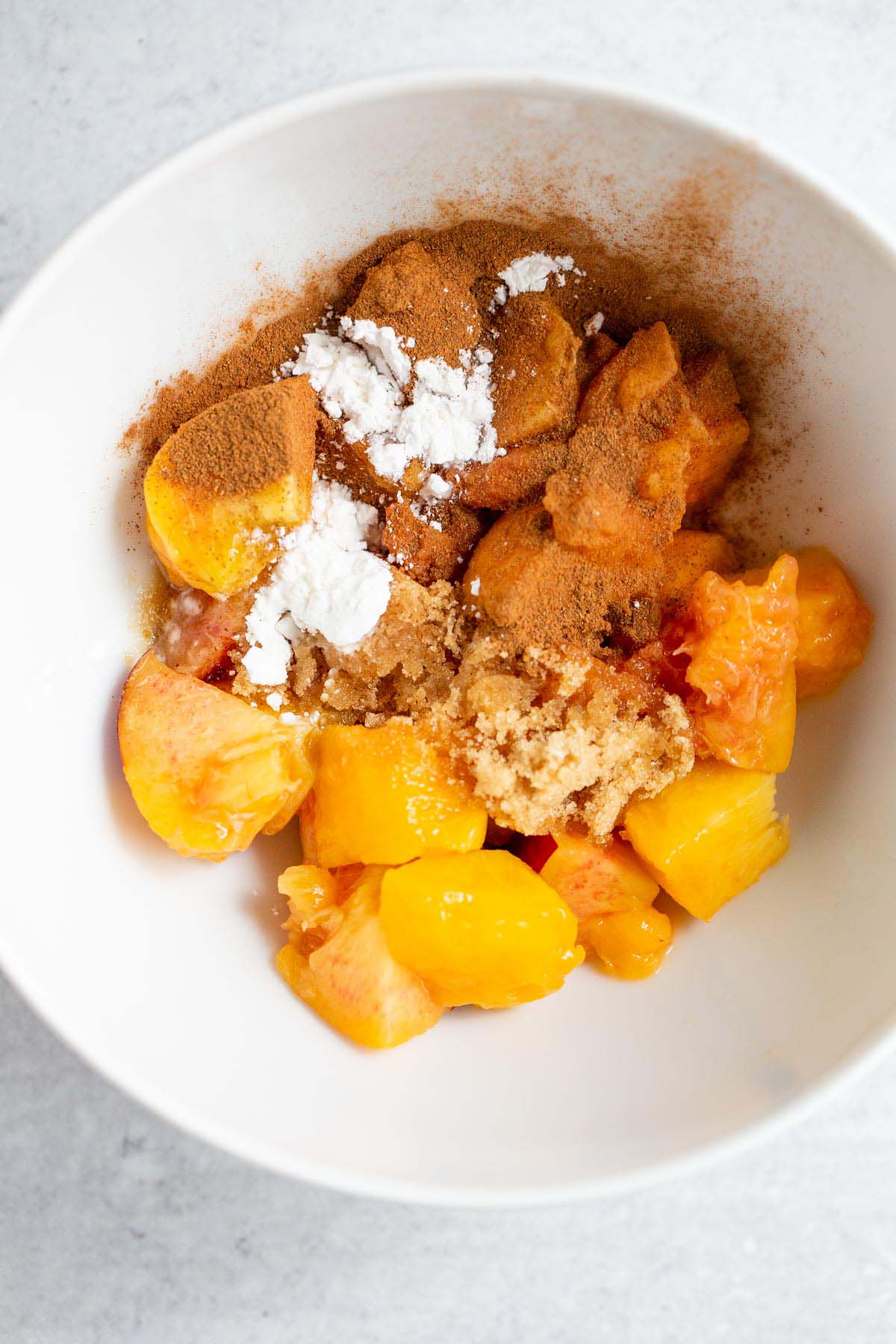 Peaches, brown sugar, cinnamon, in a bowl.