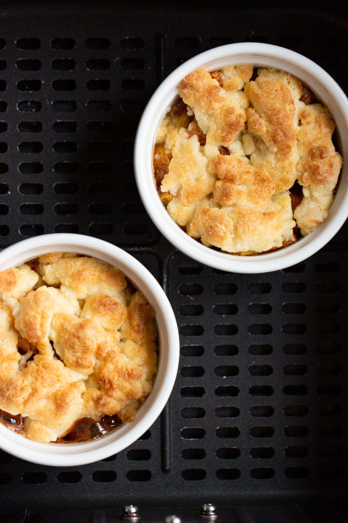 Cooked peach cobbler in air fryer basket.