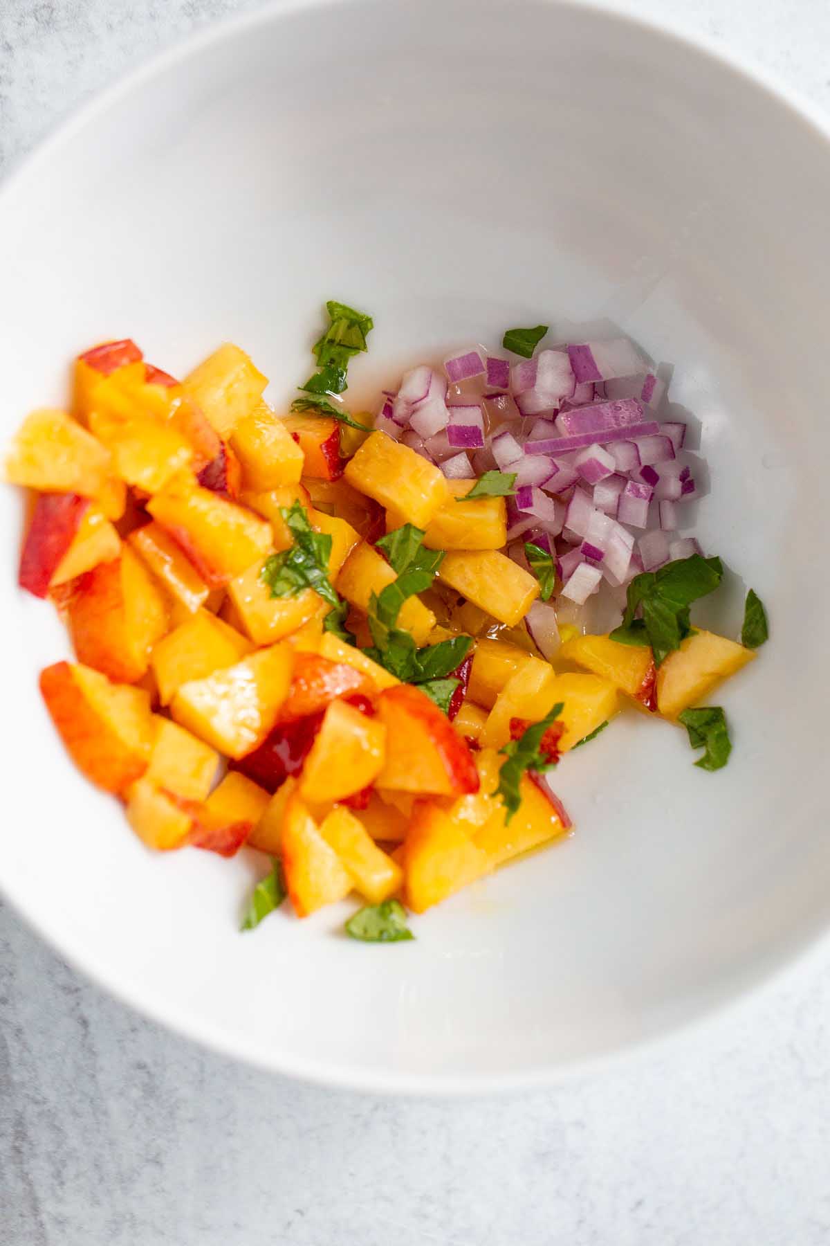 Ingredients for peach salsa in a bowl.