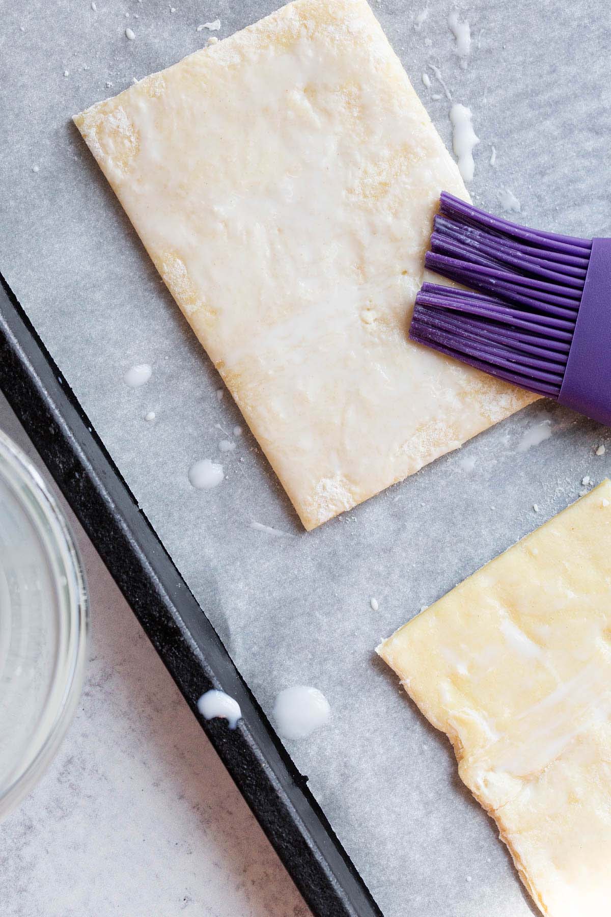 Brushing puff pastry with milk.