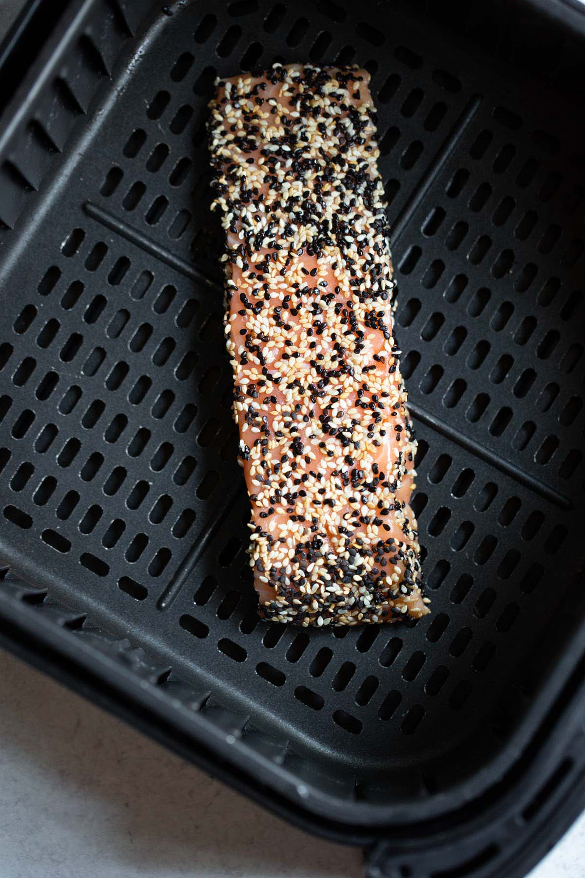 Sesame salmon in air fryer basket.