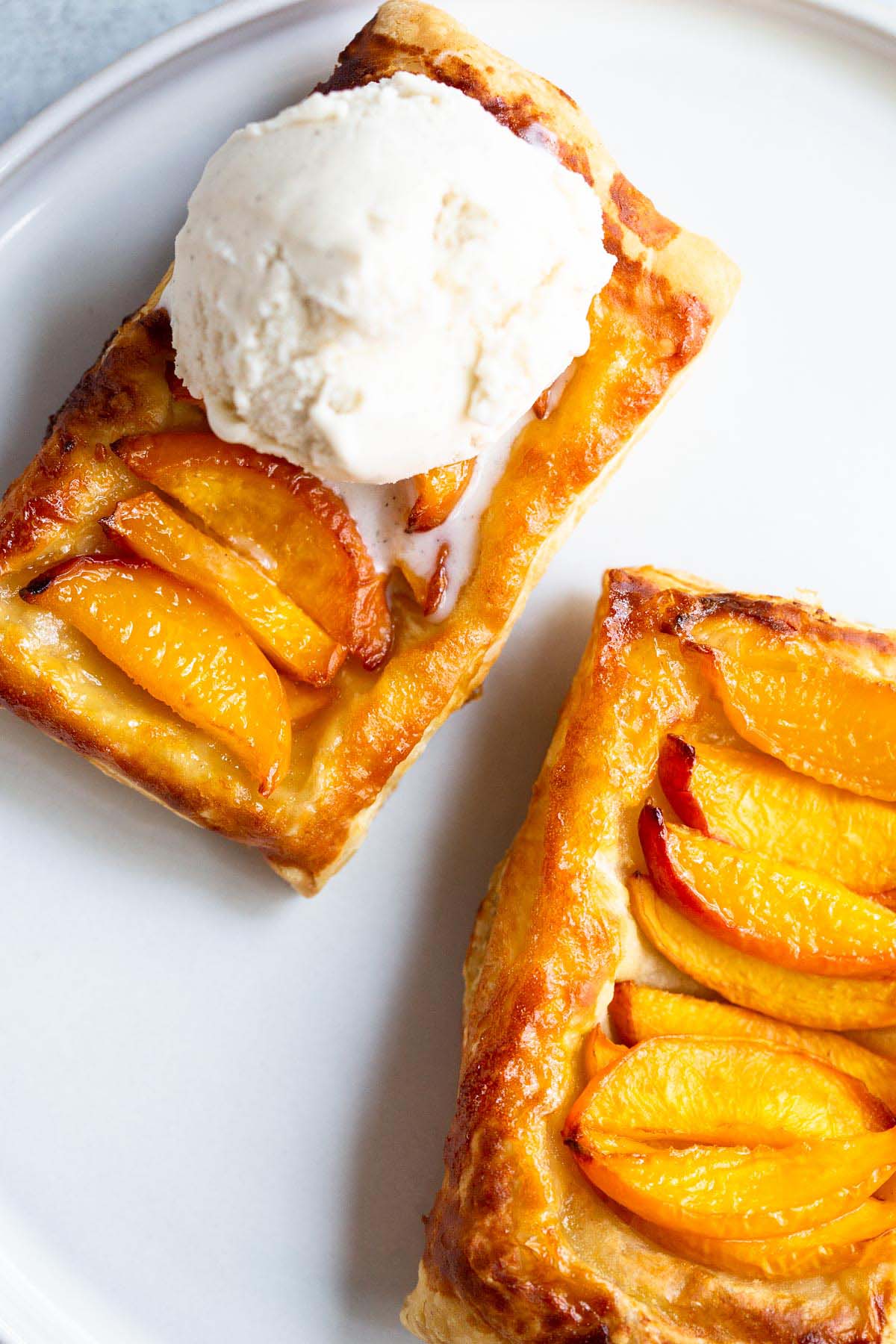 Peach puff pastry tart with ice cream.