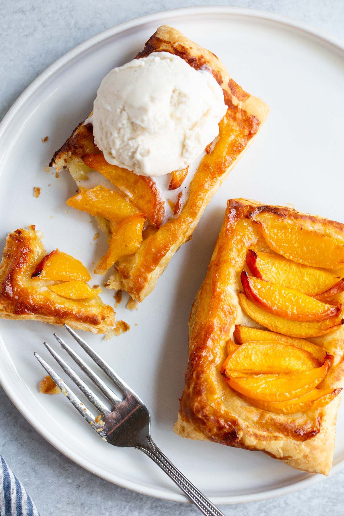 Peach puff pastry tart with ice cream.