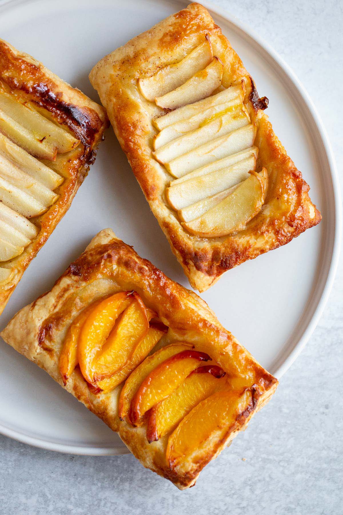 Peach and apple puff pastry tarts on a plate.