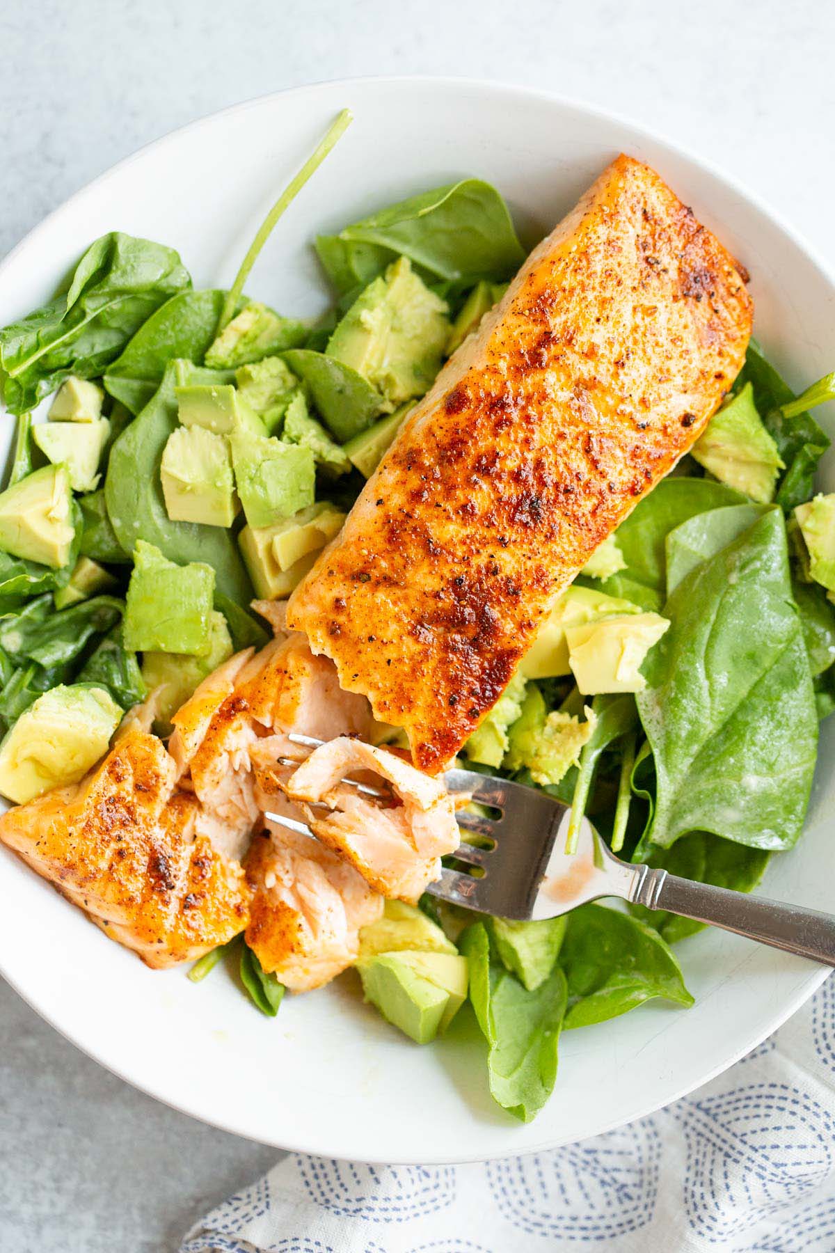 Cooked salmon over salad.