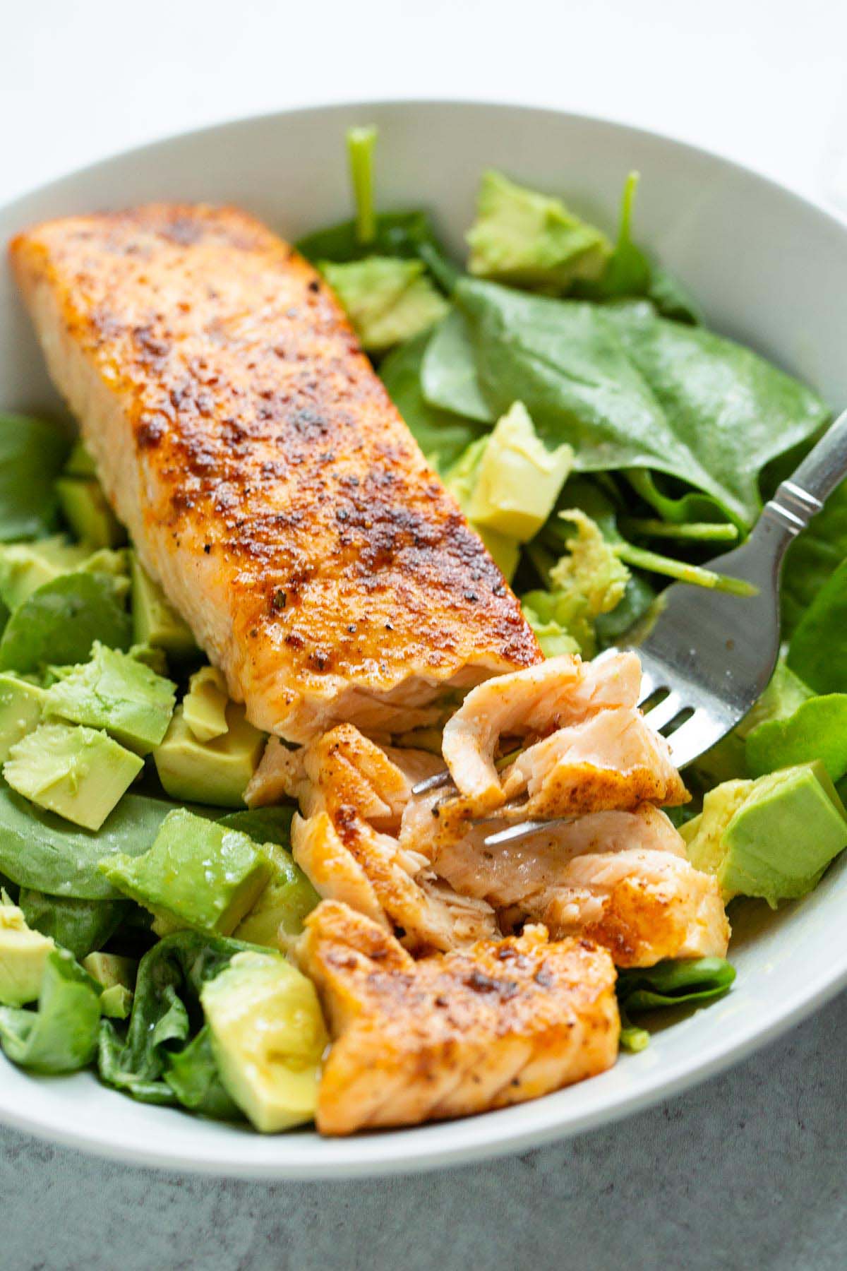 Cooked salmon on top of salad.