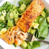 Cooked salmon over salad.