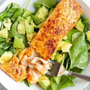 Cooked salmon over salad.