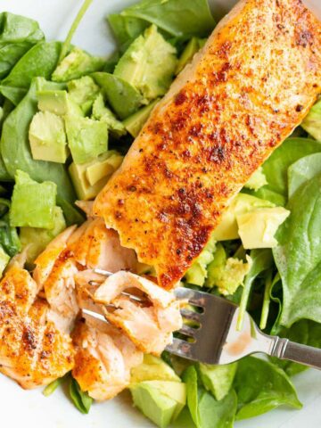 Cooked salmon over salad.