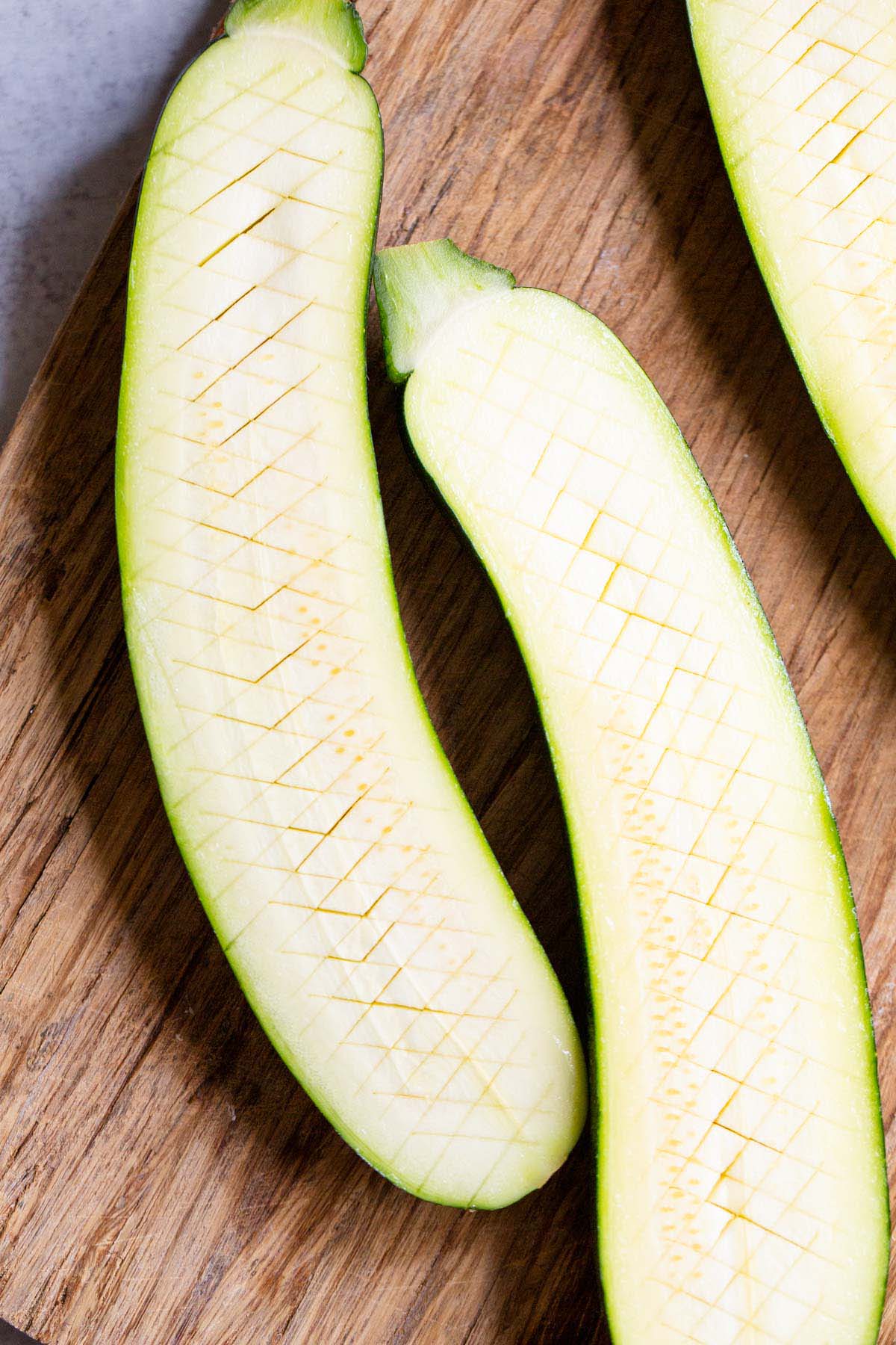 Zucchini with crisscross cut into the surface.