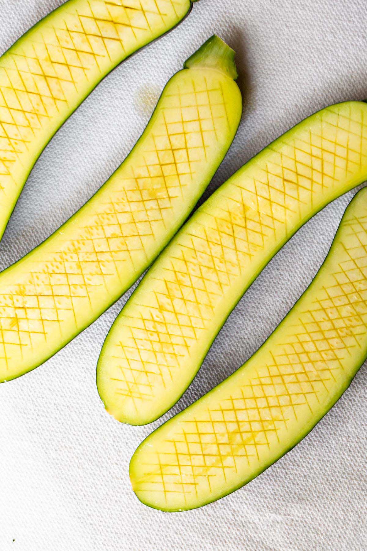 Zucchini with crisscross cut into the surface.