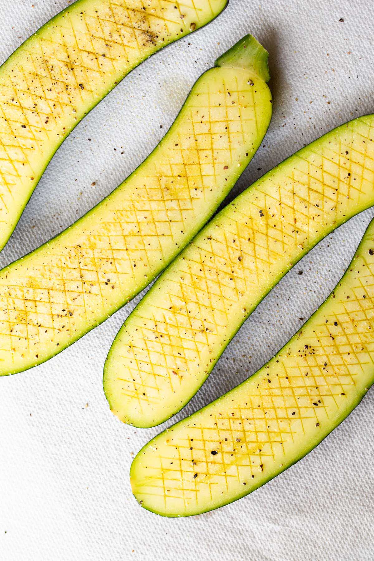 Zucchini with crisscross cut into the surface.