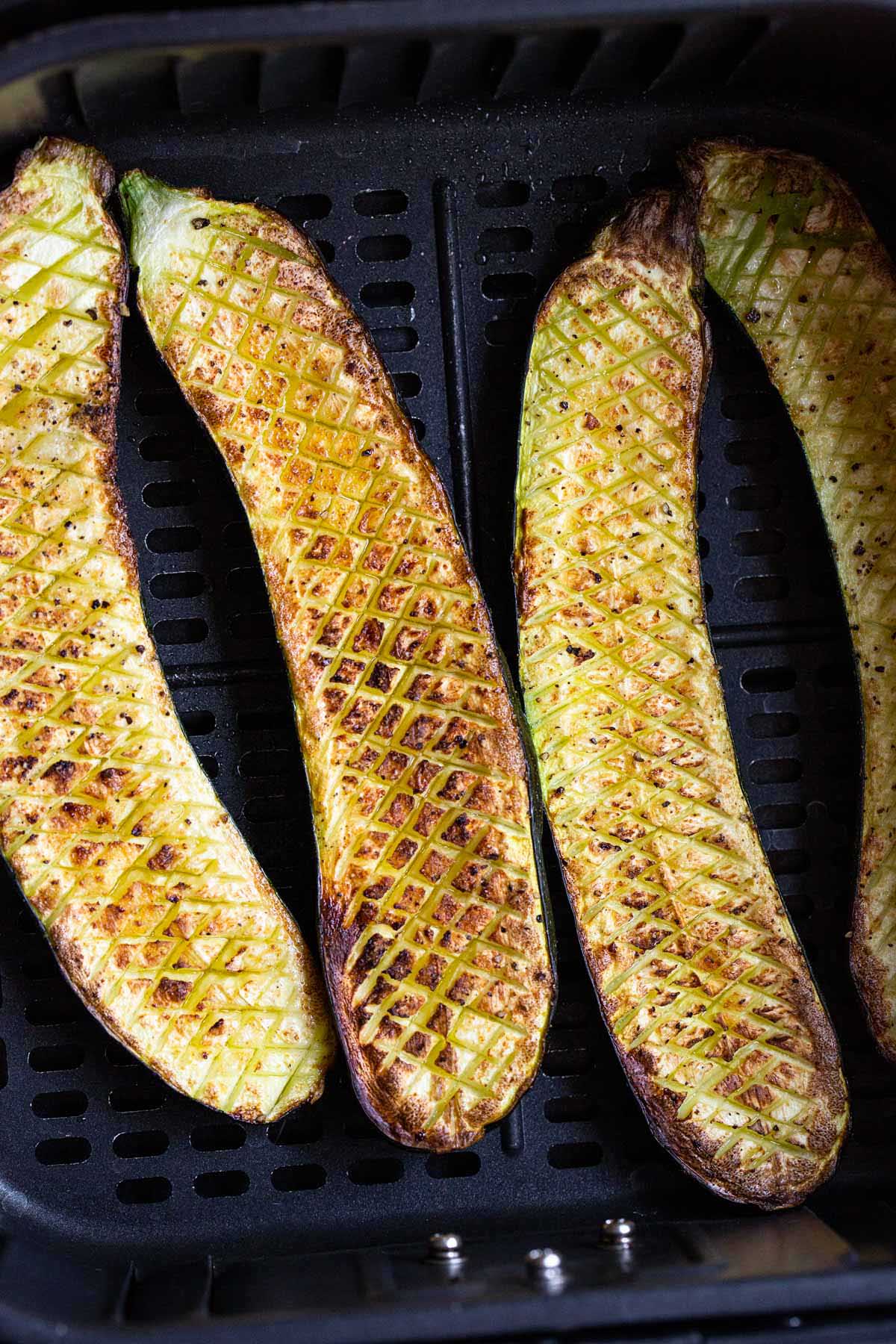 Crisscross zucchini in air fryer basket.