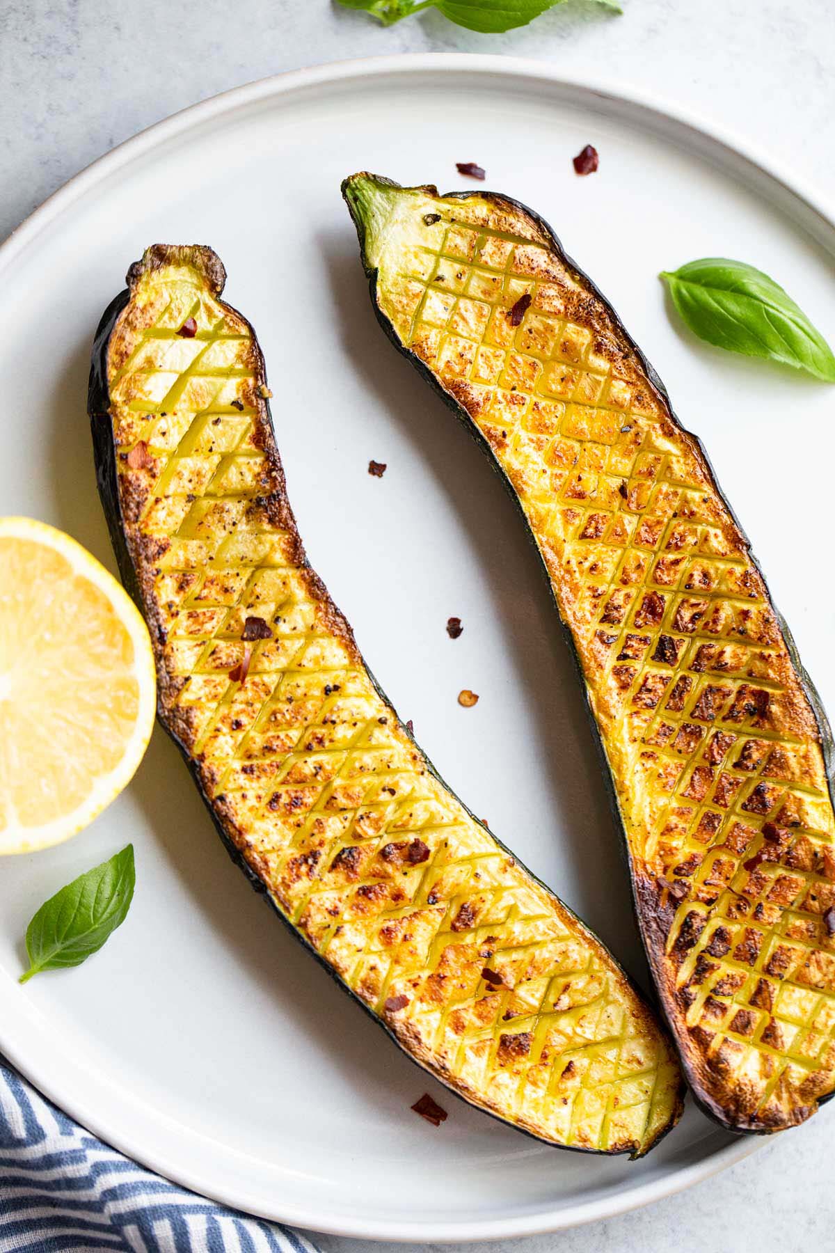 Crisscross zucchini on a white plate.