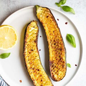 Crisscross zucchini on a white plate.