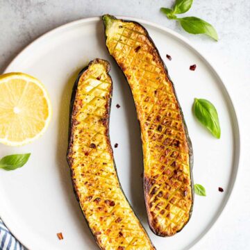 Crisscross zucchini on a white plate.