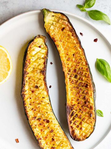 Crisscross zucchini on a white plate.