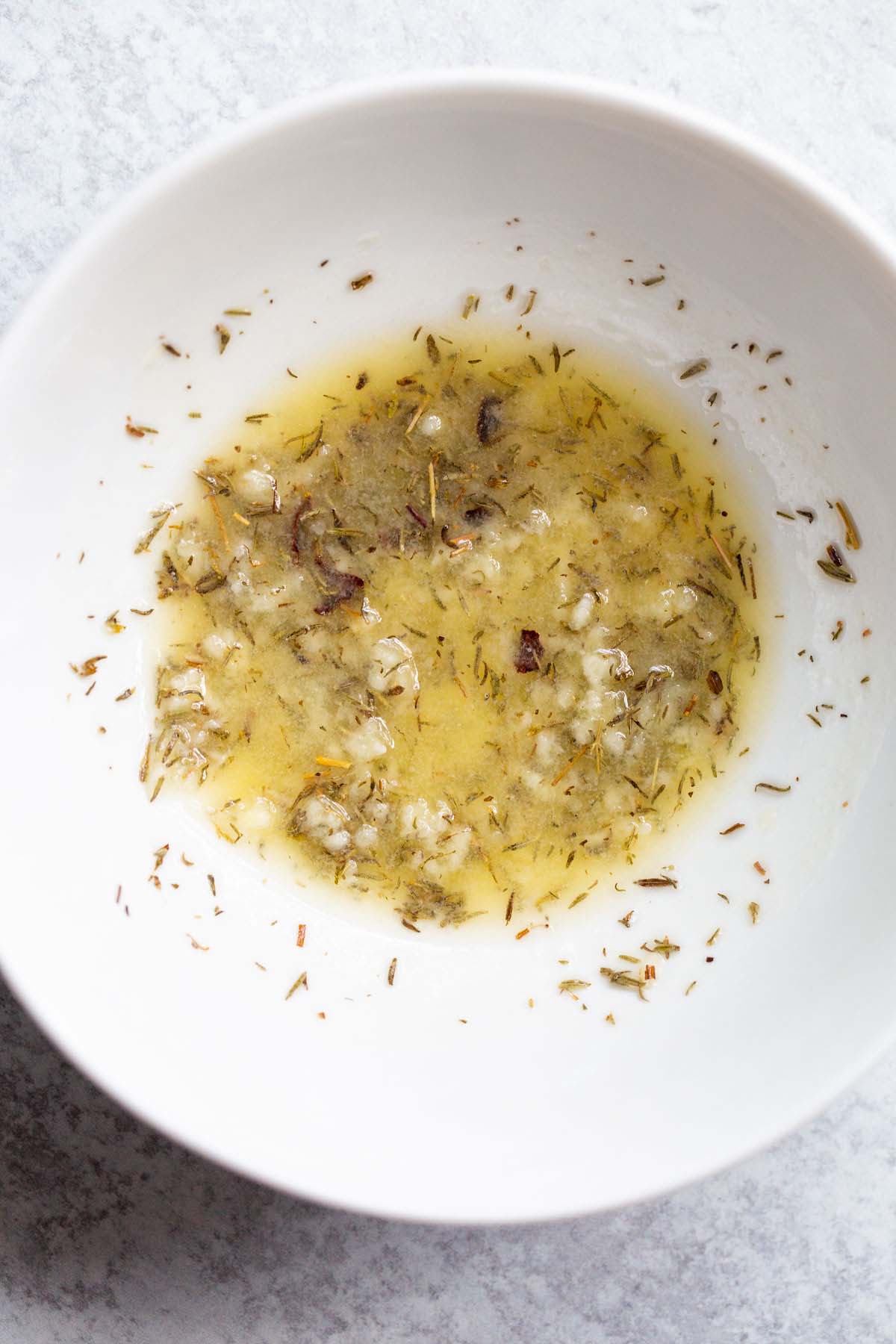 Herbs and melted butter in a bowl.