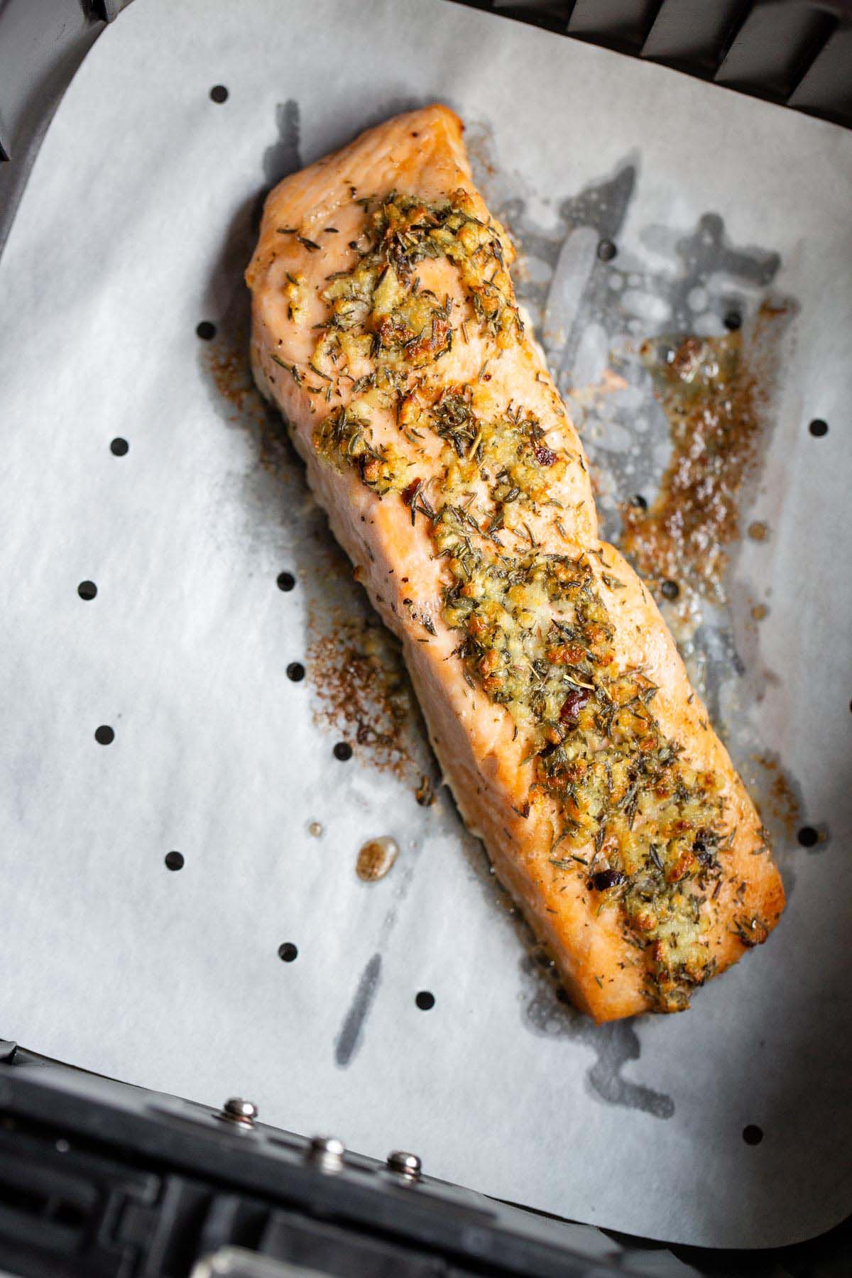 Cooked salmon in air fryer basket.