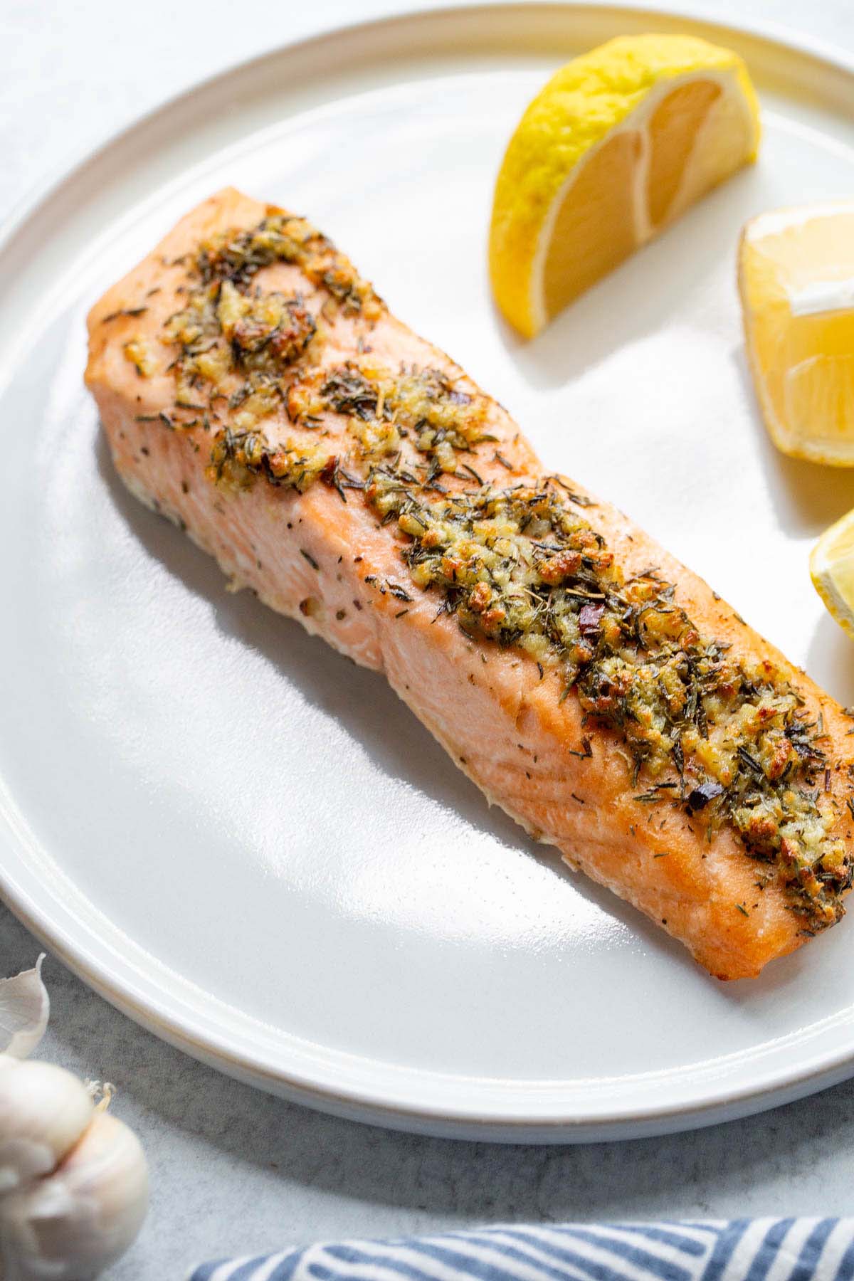 Salmon on a plate with lemons on the side.