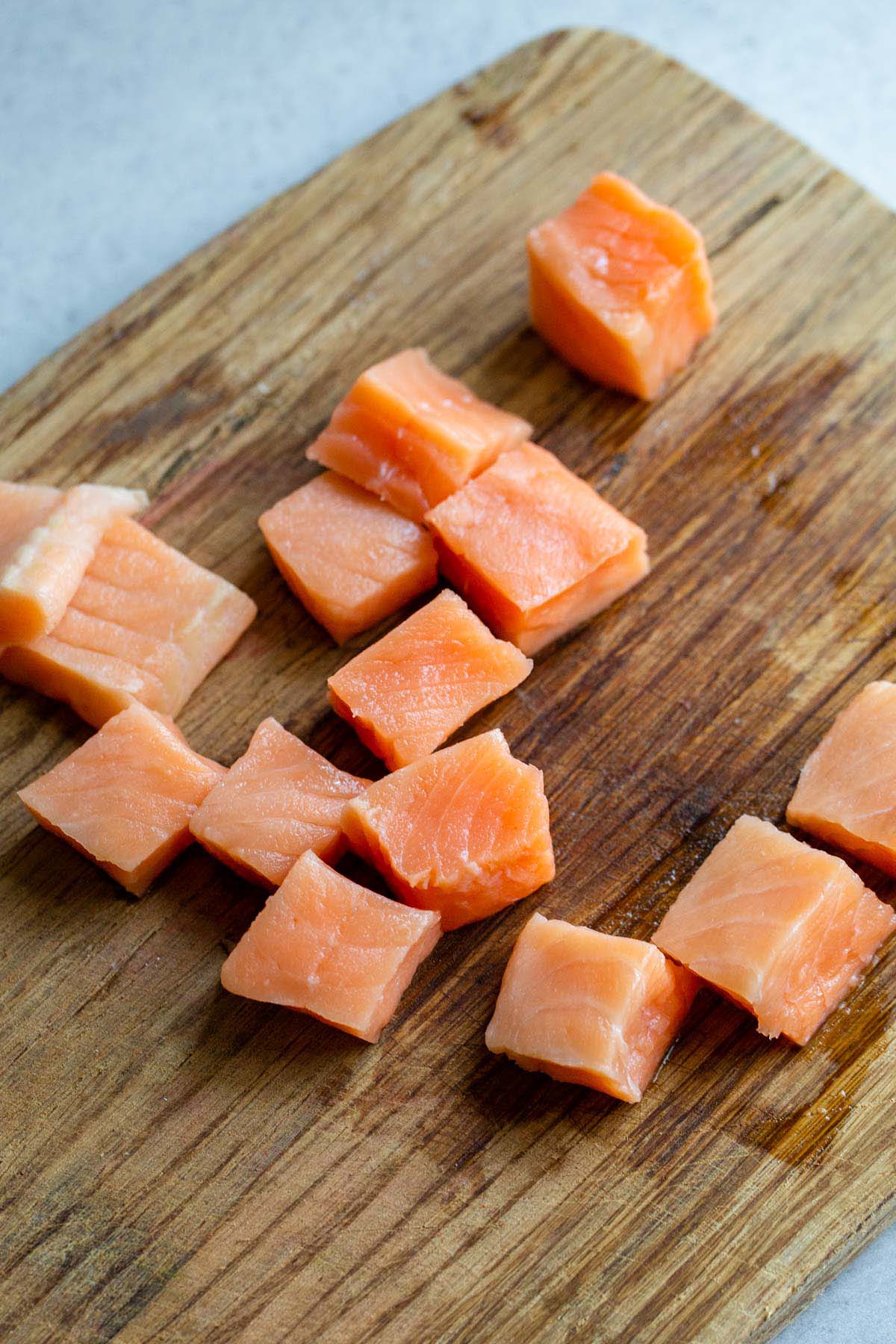 Salmon cubes on a cutting board.