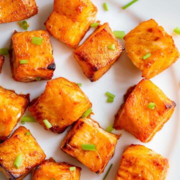 Salmon bites on a white plate.