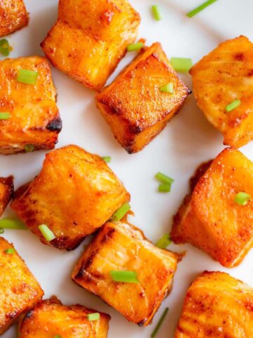 Salmon bites on a white plate.