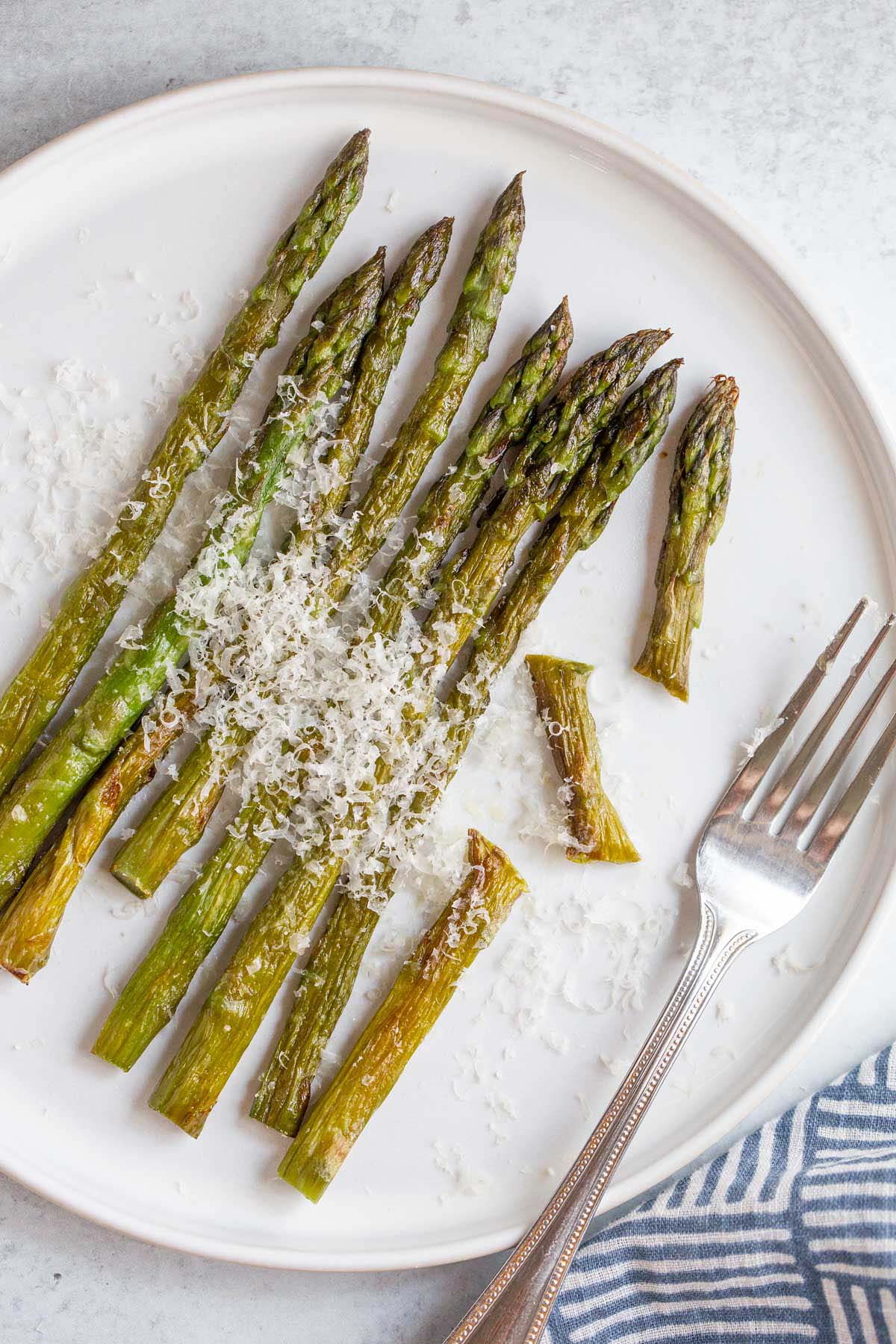 Asparagus on a plate with a fork.