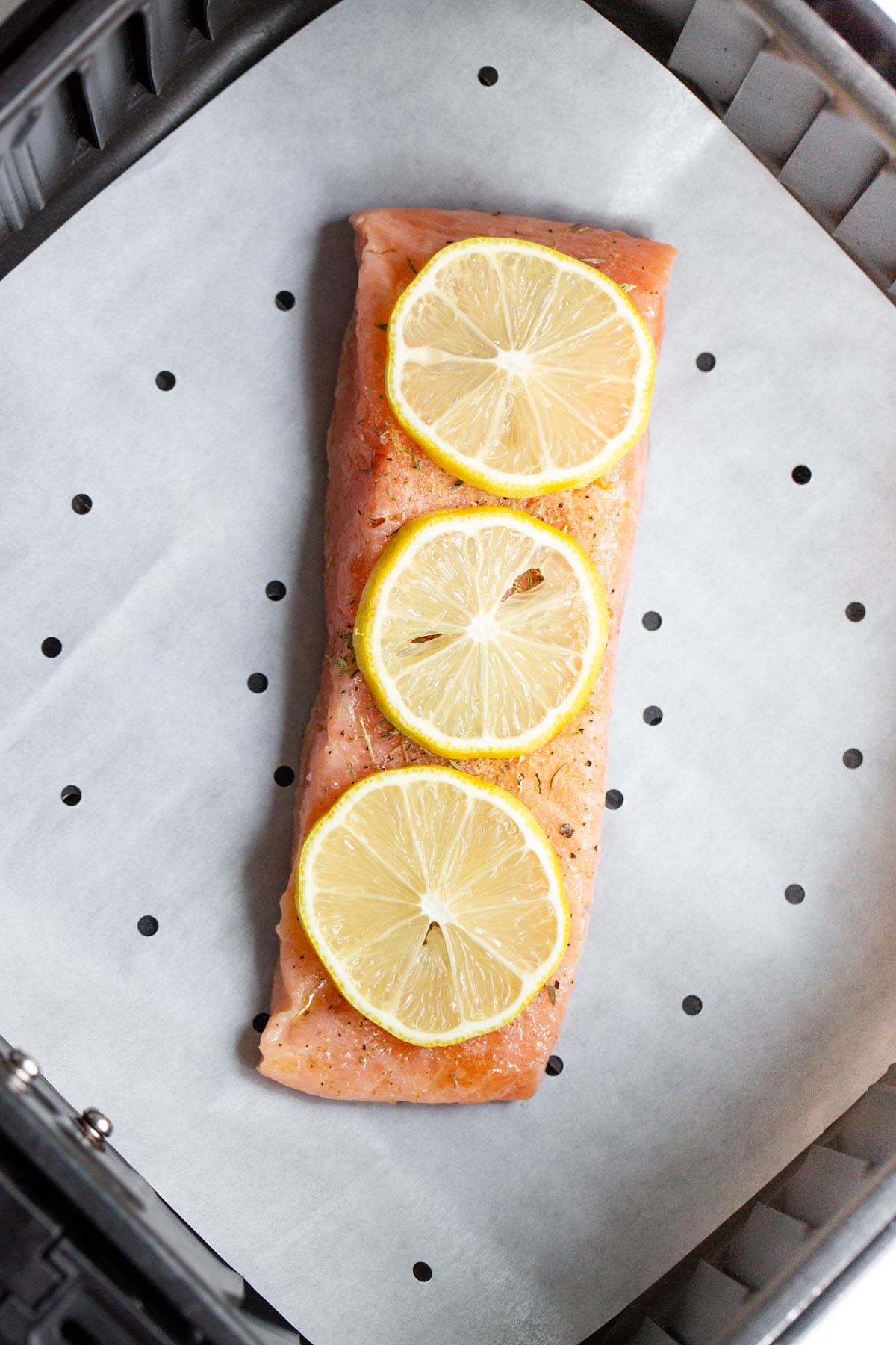 Salmon in air fryer basket.