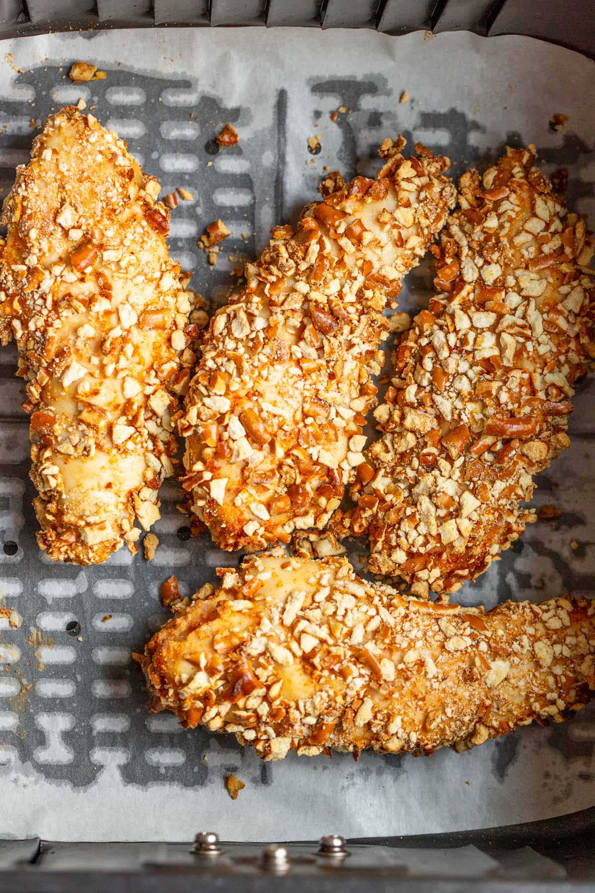 Cooked chicken in the air fryer basket.