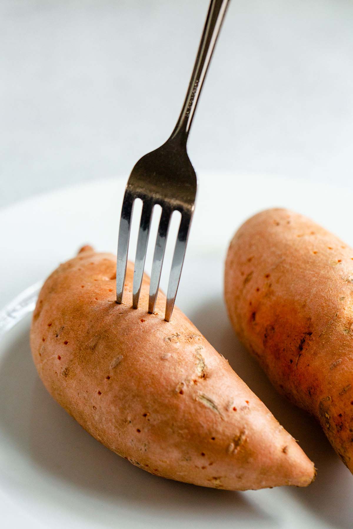 Sweet potato being poked with a fork.