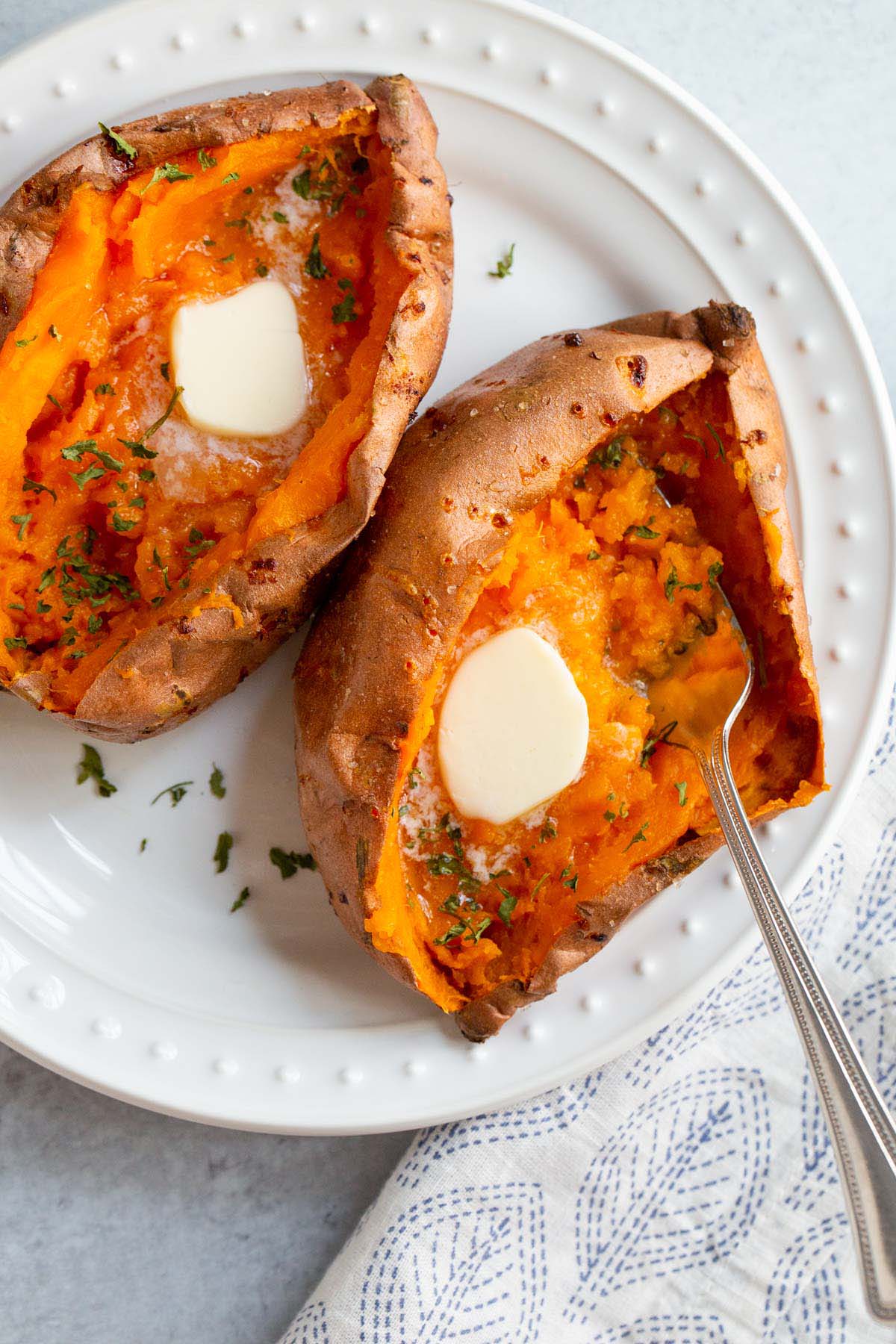 Baked sweet potato with butter and parsley.