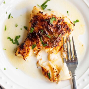 Air fried chili lime cod on a plate with parsley.