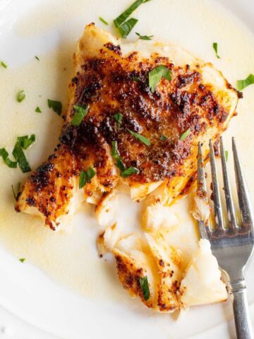 Air fried chili lime cod on a plate with parsley.