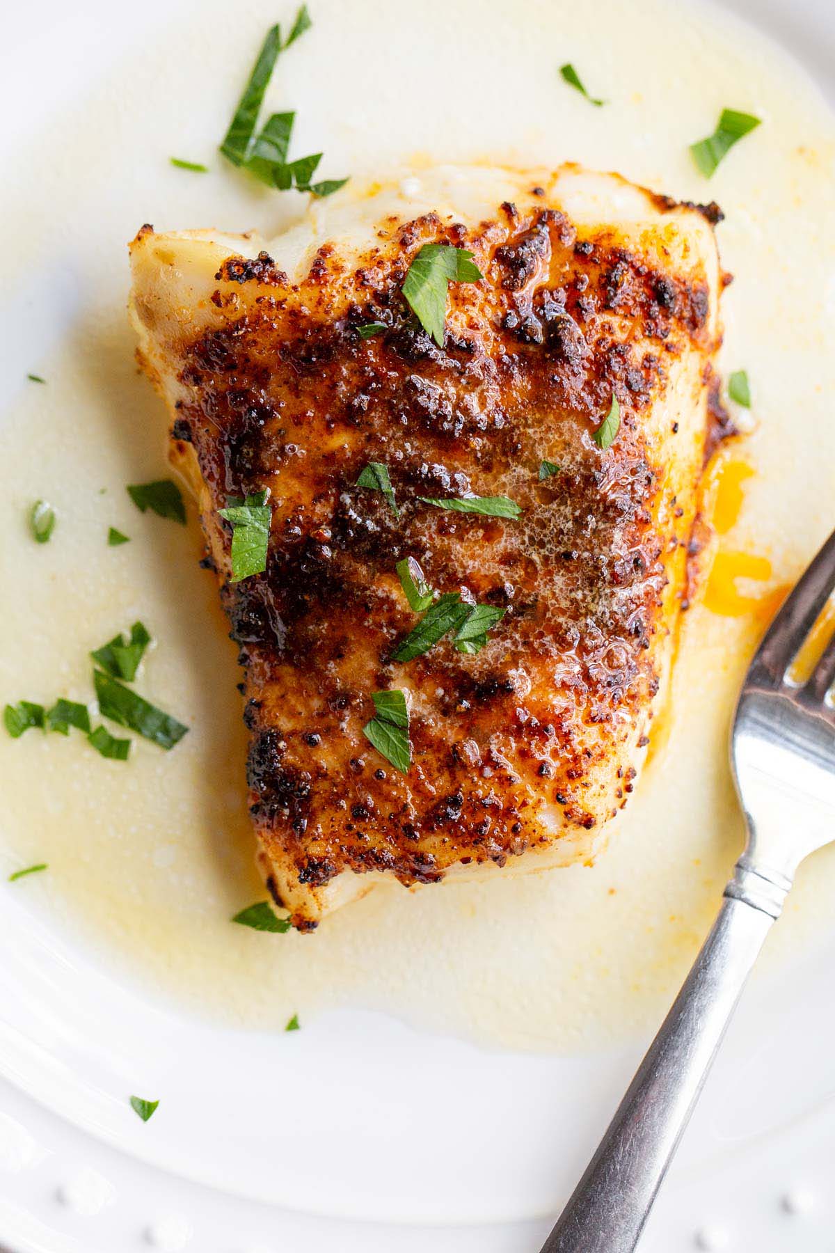 Air fried chili lime cod on a plate with parsley.