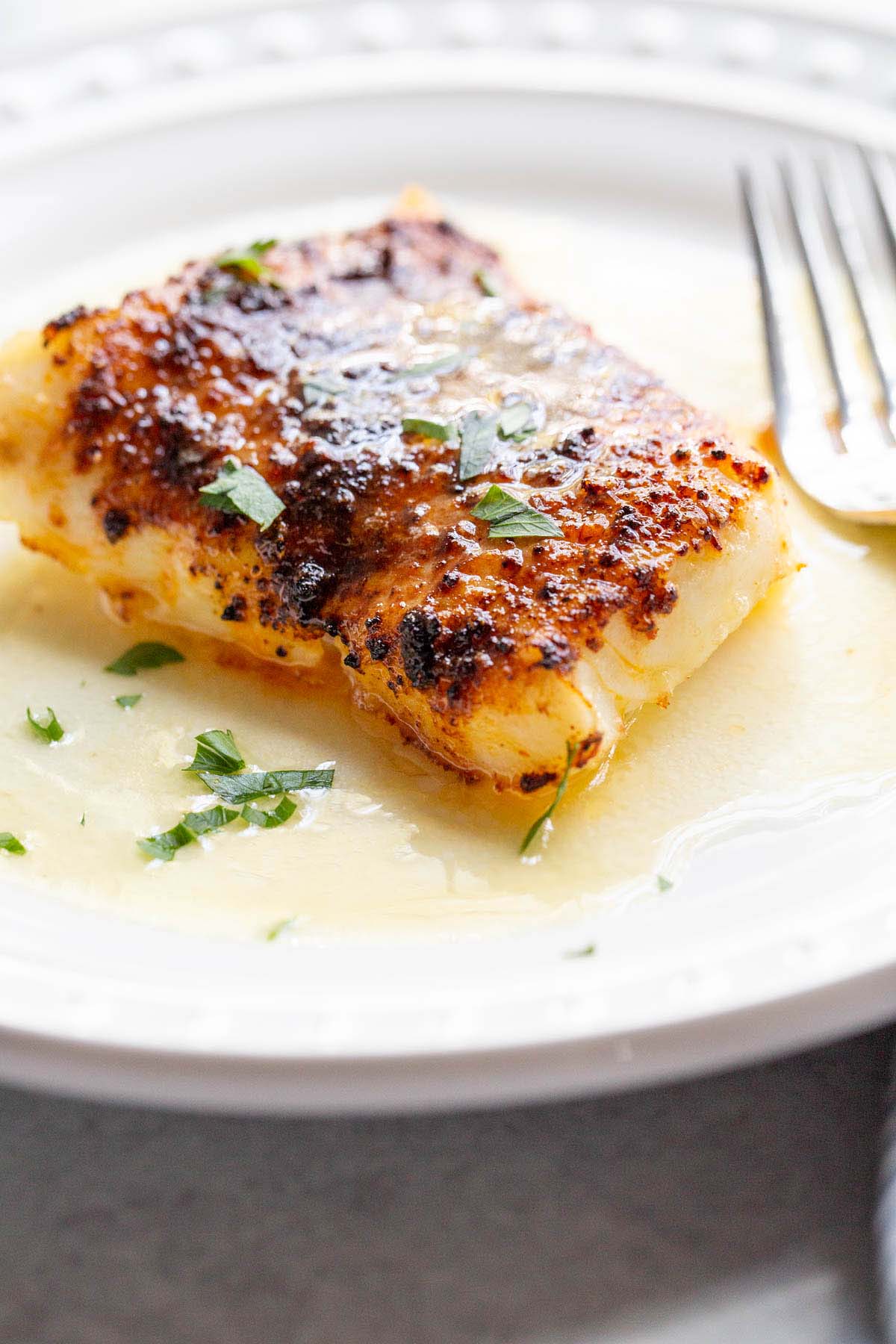 Air fried chili lime cod on a plate with parsley.