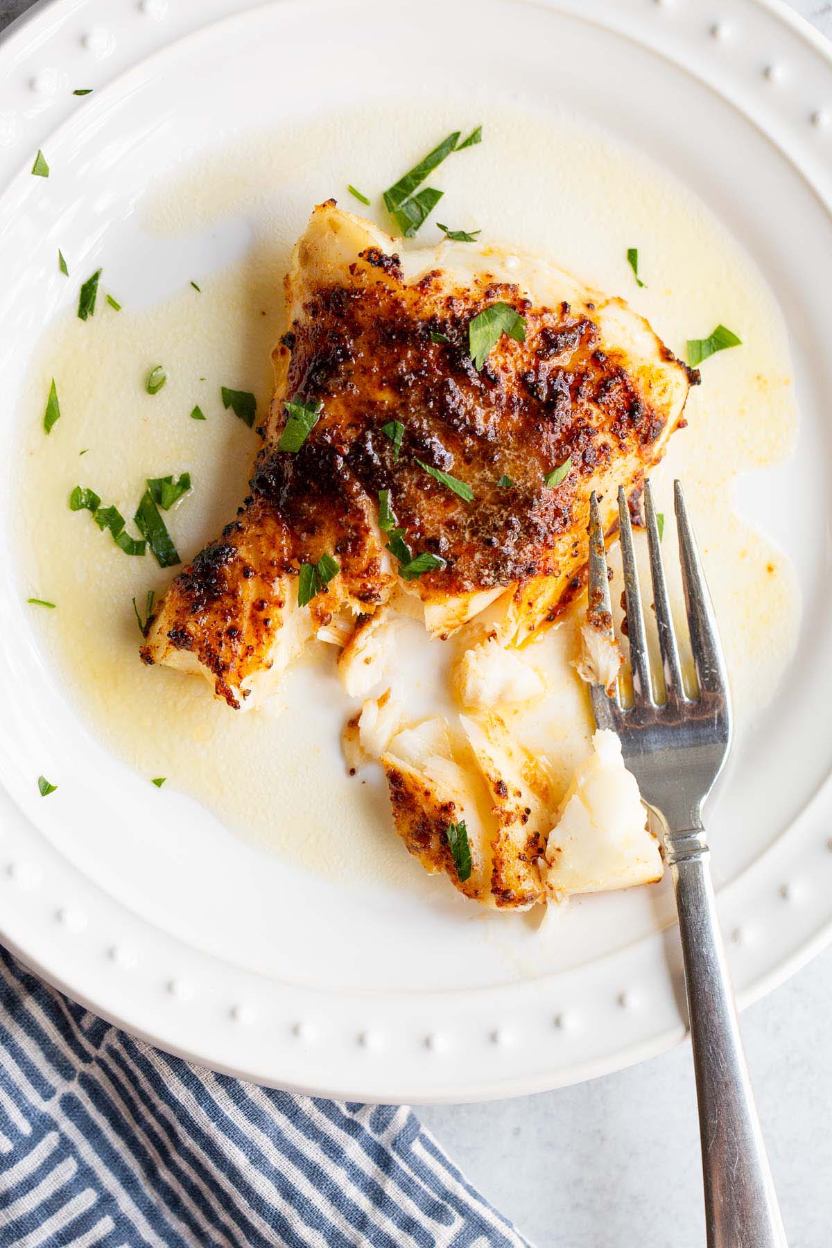 Air fried chili lime cod on a plate with parsley.