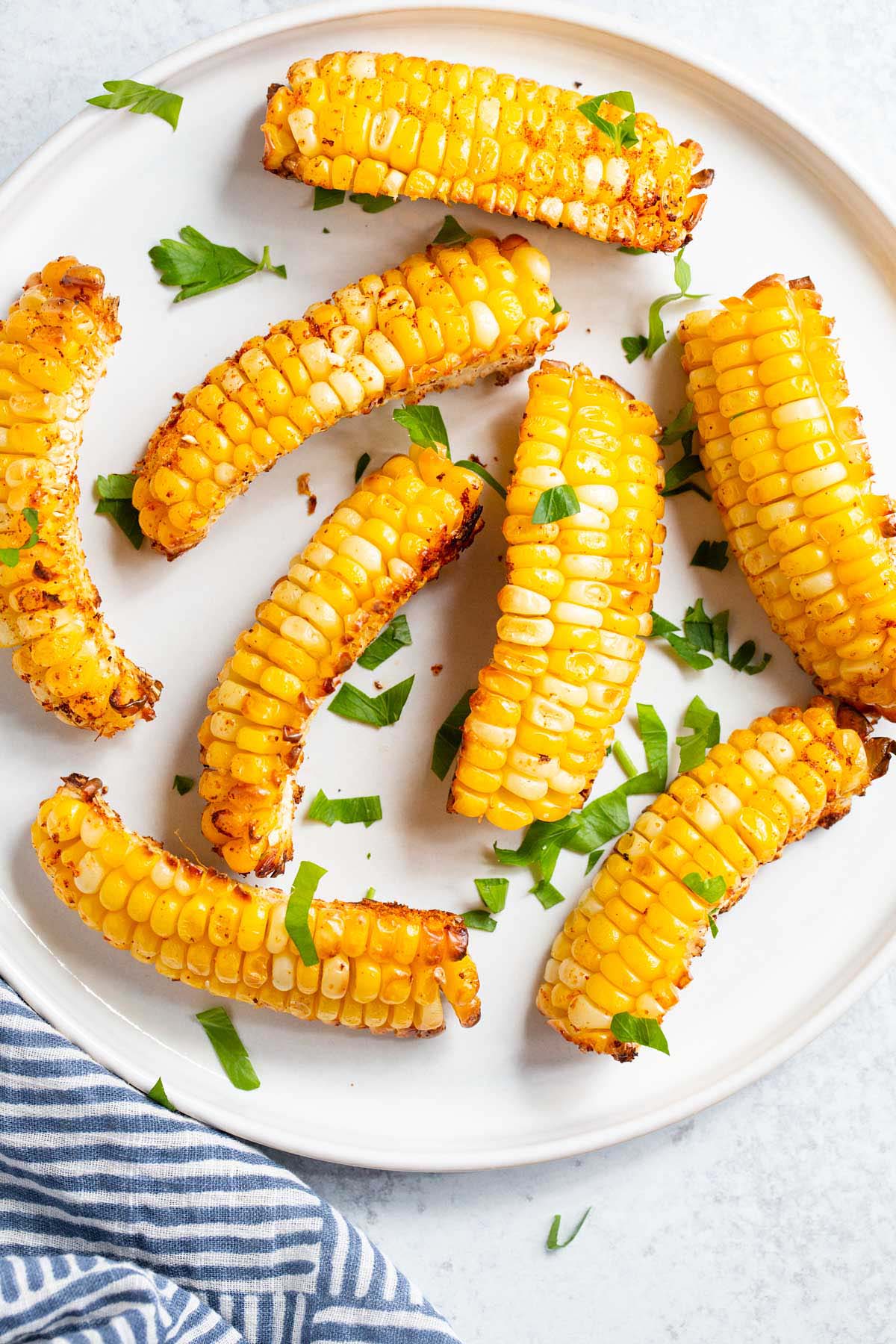 Corn ribs on a white plate with parsley.