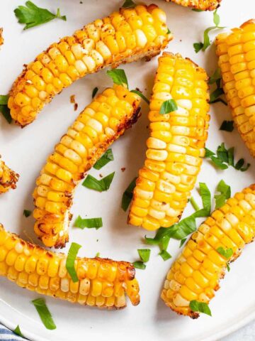 Corn ribs on a white plate with parsley.