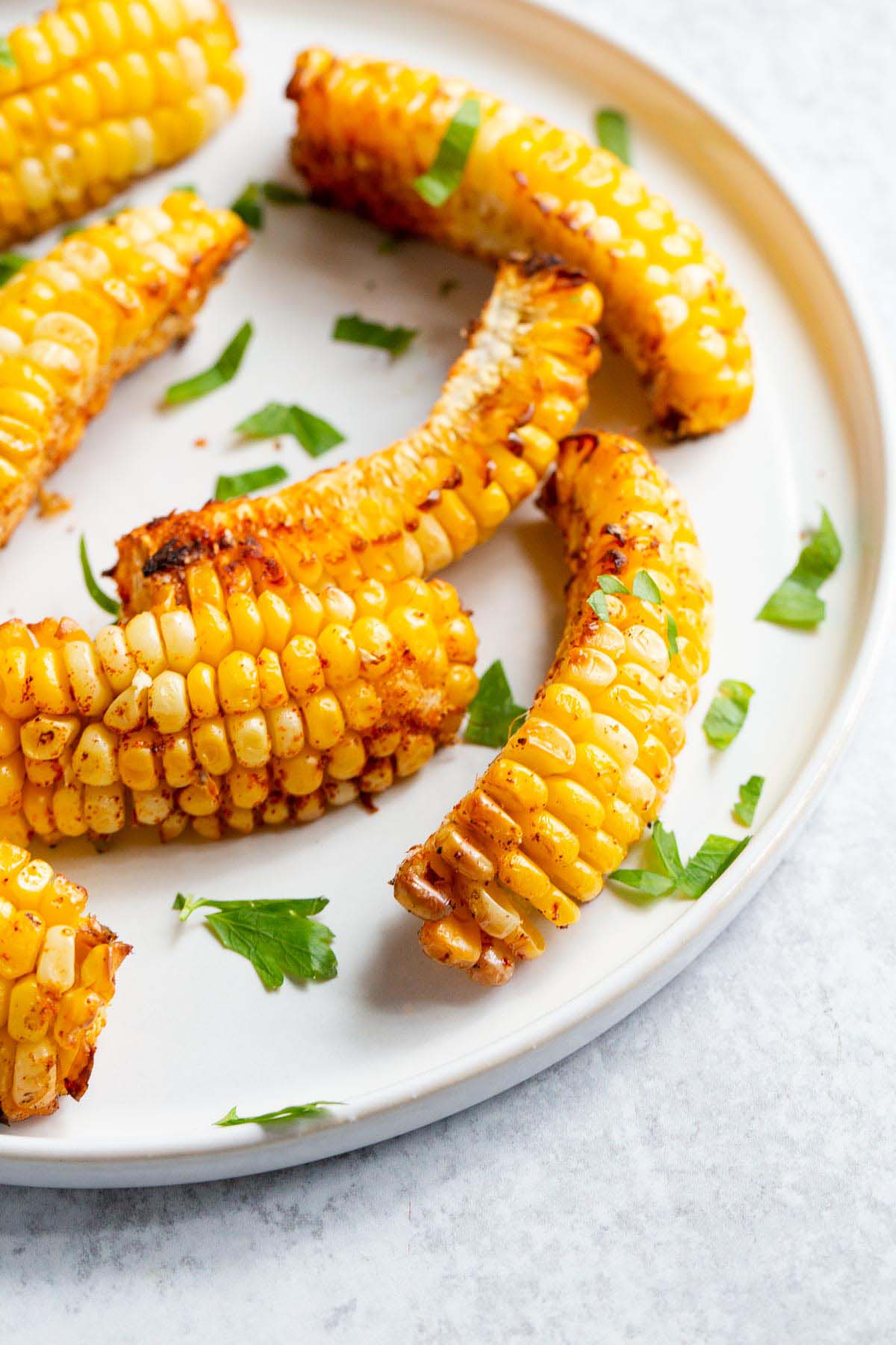 Corn ribs on a white plate with parsley.