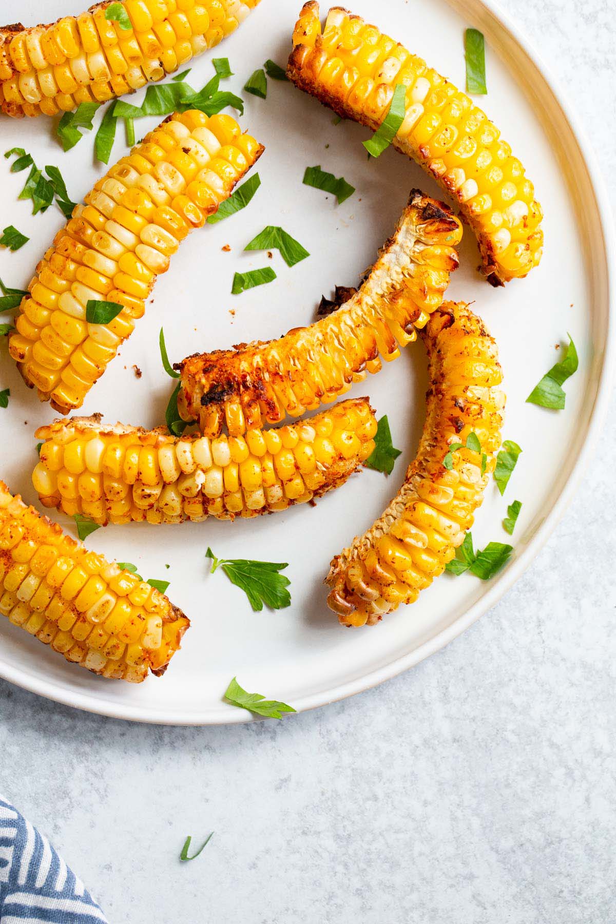 Corn ribs on a white plate with parsley.